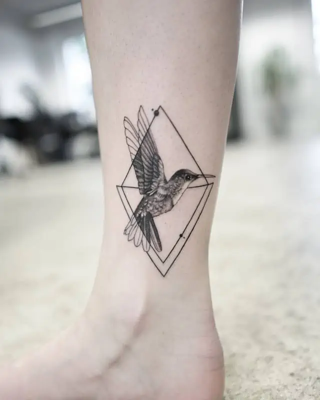 tatouage géométrique d'un oiseau à la cheville avec un diamant