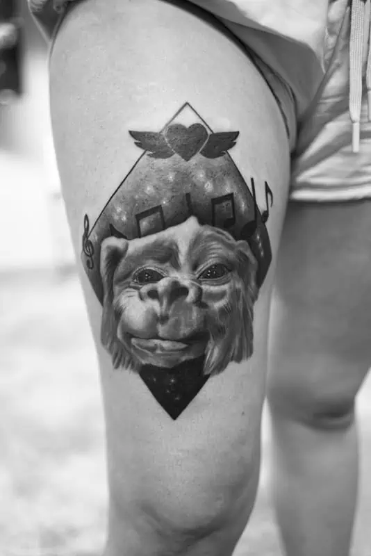monkey on thigh geometric tattoo