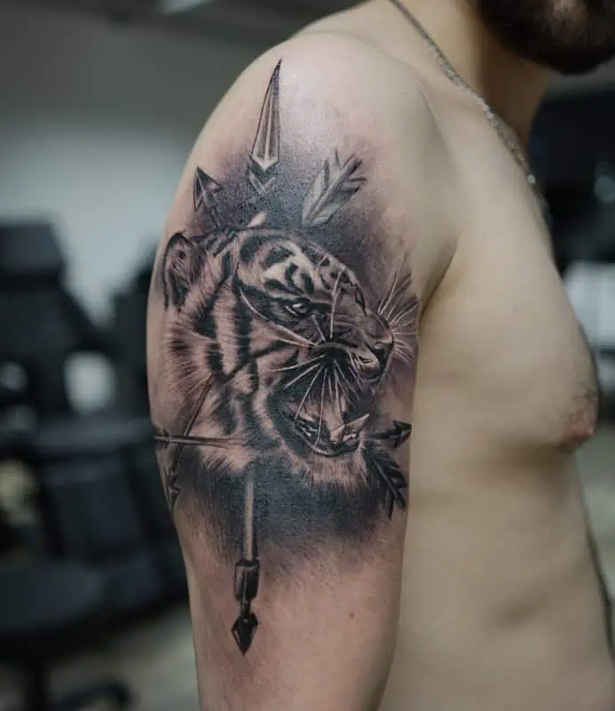 tiger with arrows arm tattoo