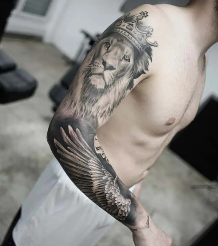 feathers and lion on arm tattoo realistic